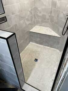 A newly tiled shower with a built-in bench installed by Premier Handyman Services in Lexington, KY.