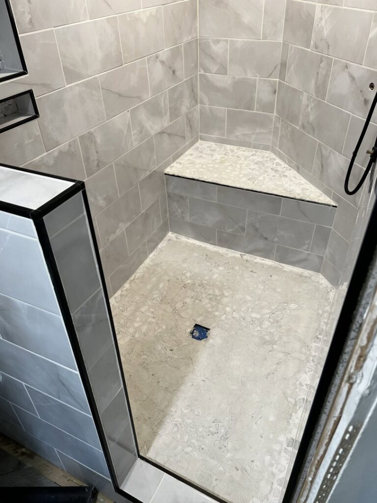 A newly tiled shower with a built-in bench installed by Premier Handyman Services in Lexington, KY.
