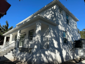 Side exterior view of a newly built house with an AC unit by Otero-Cossio Construction in Tampa, FL.