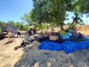 A large pile of household junk on a sidewalk, being removed by Haul-R-Us Junk Removal LLC workers in Fresno, CA.