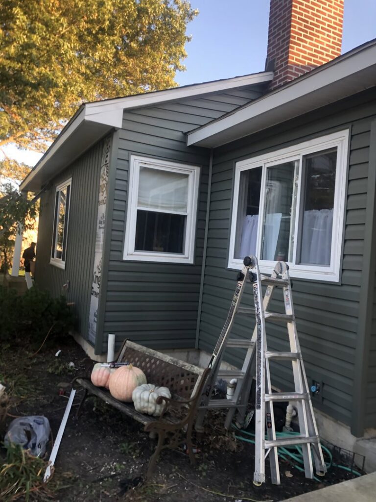 New dark green siding being installed on the side of a residential house by Mp painting and roofing LLC in Dayton, OH