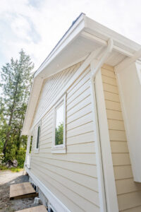 Side of a house with light siding and a ladder, indicating exterior work by Ideal Siding Memphis, TN