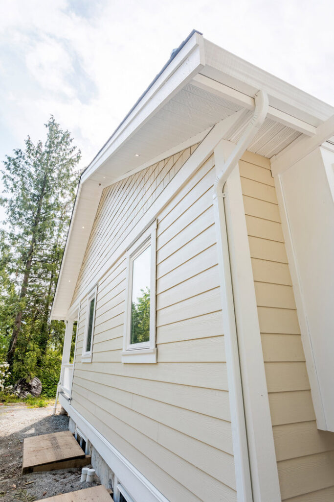 Side of a house with light siding and a ladder, indicating exterior work by Ideal Siding Memphis, TN