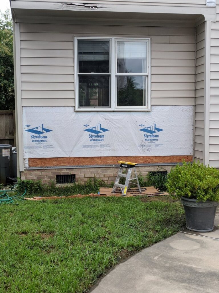 Exterior wall with insulation wrap and exposed framing during siding repair or installation by The Home Pros in Virginia Beach, VA