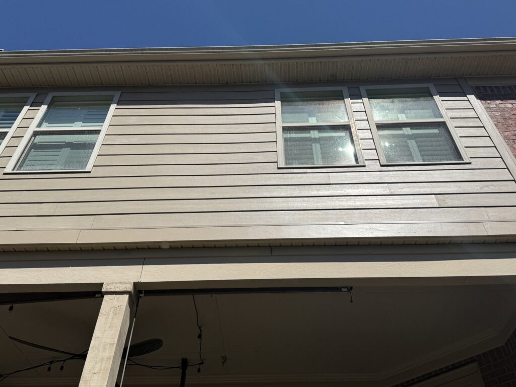 Newly replaced siding on a house, showcasing clean lines around the windows by Music City Exteriors in Nashville, TN