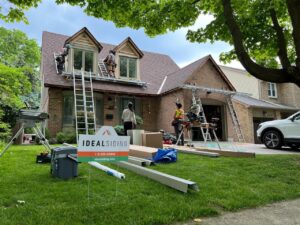 Workers installing siding and roofing on a house, a handyman job by Ideal Siding Memphis, TN