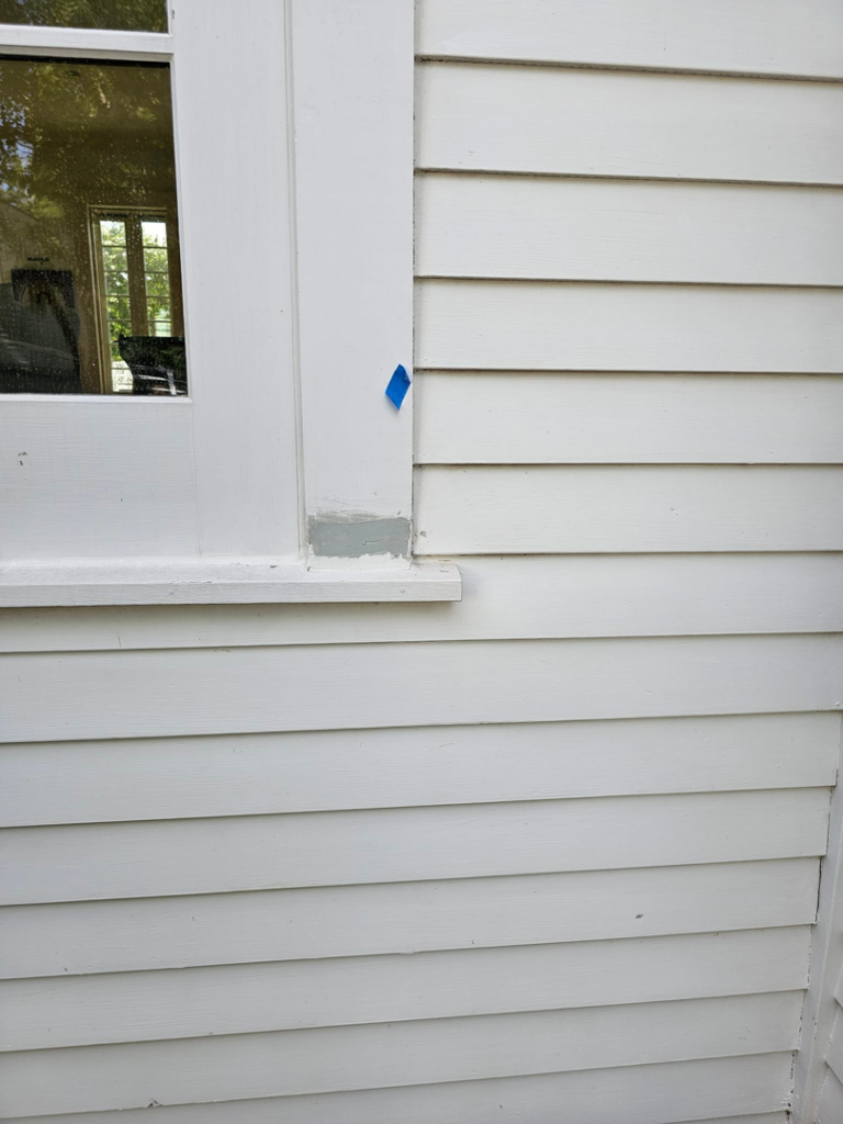 Exterior siding and window trim repair with blue tape by KTL Home Repair and Remodeling in Norman, OK