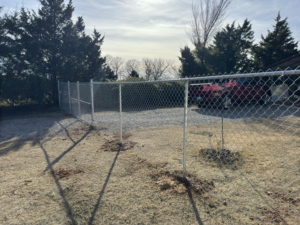 Newly installed silver chain-link fence with a gate for a property entrance by Herron Fencing LLC in Shawnee, OK.