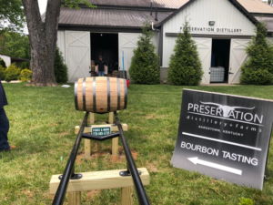 A single whiskey barrel on a custom display stand with a Fence & More sign in Elizabethtown, KY