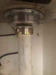 The underside of a sink showing a drain pipe connection, indicating plumbing installation or repair by Mancusi Home Maintenance in Boulder City, NV.