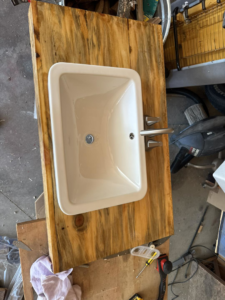 A sink installed into a custom wooden vanity top with a new faucet by Shurigar Home Repair & Handyman in Kenesaw, NE.