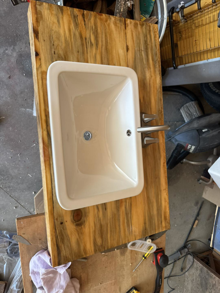 A sink installed into a custom wooden vanity top with a new faucet by Shurigar Home Repair & Handyman in Kenesaw, NE.