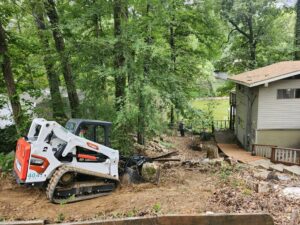 A skid steer loader working at a demolition or site clearing job, part of MS Dump & Haul services in Hernando, MS.