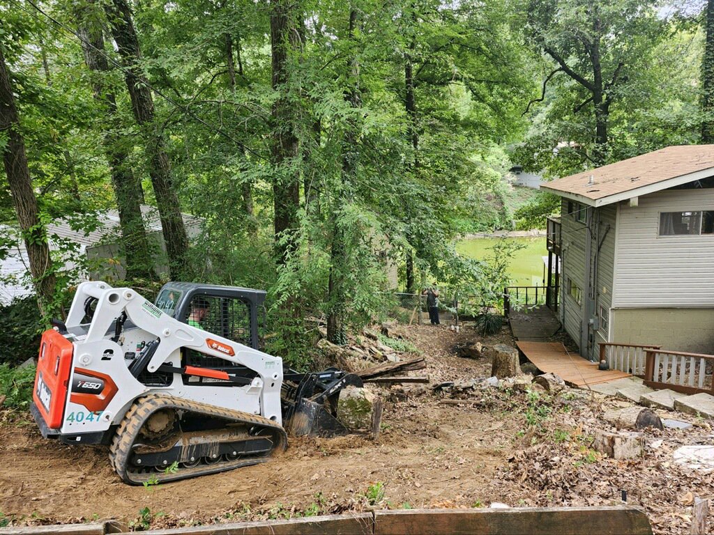 A skid steer loader working at a demolition or site clearing job, part of MS Dump & Haul services in Hernando, MS.
