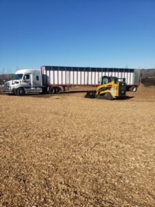 A skid steer loader loading wood chips into a semi-trailer at Wood Recycling Site / Brush Dump in Rochester, MN