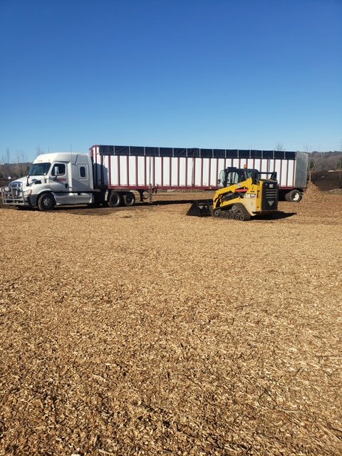 A skid steer loader loading wood chips into a semi-trailer at Wood Recycling Site / Brush Dump in Rochester, MN