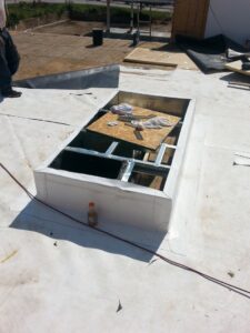 A skylight opening being prepared on a roof, showing construction work by County Toppers in Olathe, KS