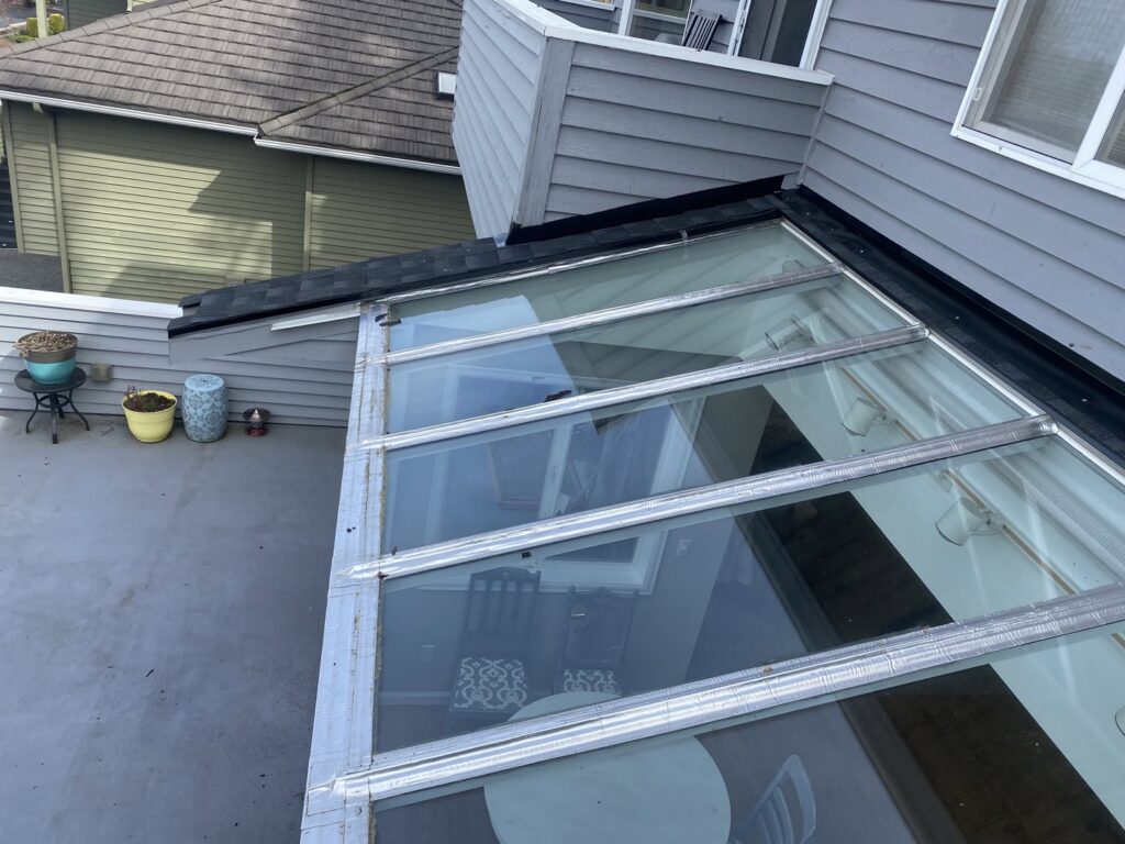 A large skylight or glass roof section being installed or repaired by Sunny's roofing LLC in Denver, CO.