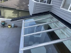 A large skylight or glass roof section being installed or repaired by Sunny's roofing LLC in Denver, CO.