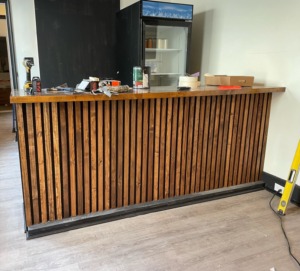 Construction of a slatted wood bar with tools visible by North Shore Construction & Renovation in Philadelphia, PA.