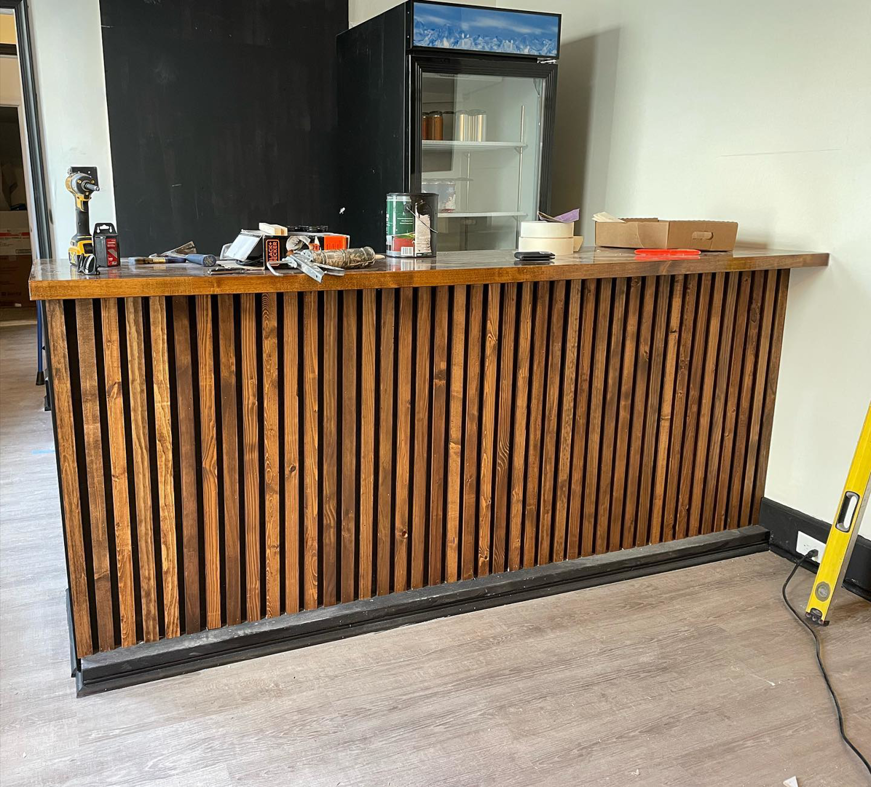 Construction of a slatted wood bar with tools visible by North Shore Construction & Renovation in Philadelphia, PA.