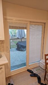 A newly installed sliding glass patio door leading to an outdoor deck by NC Siding and Windows in Raleigh, NC