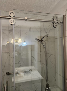 A newly installed sliding glass shower door system in a tiled bathroom by Tim's handyman service in Cherry Hill, NJ.