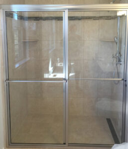 A contemporary bathroom upgrade featuring a sliding glass shower door and beautifully tiled walls by Lehigh Shower Glass in Bethlehem, PA