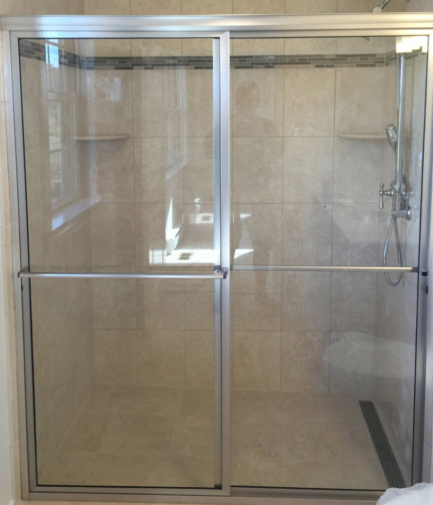 A contemporary bathroom upgrade featuring a sliding glass shower door and beautifully tiled walls by Lehigh Shower Glass in Bethlehem, PA