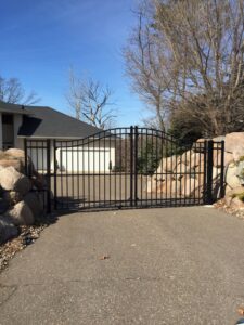 A black metal fence installed along a sloped residential property by Security Fence & Construction Inc in Minneapolis, MN.