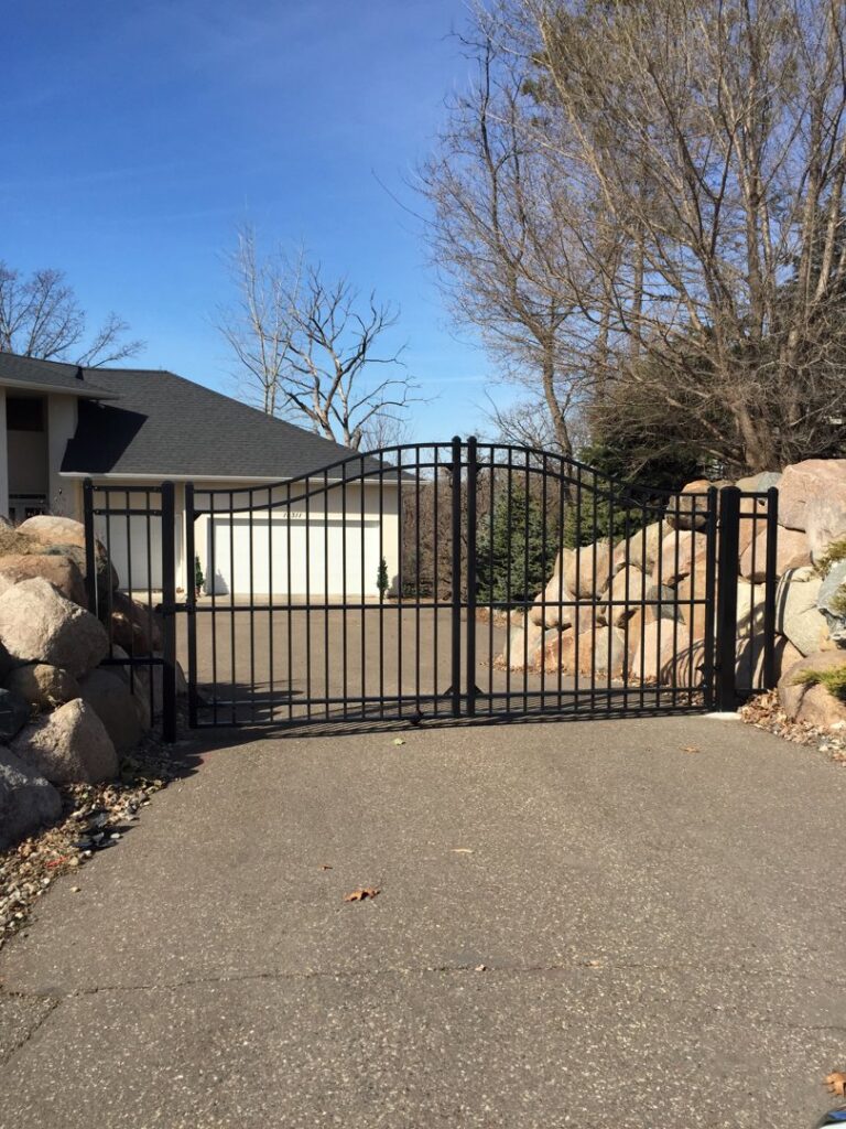 A black metal fence installed along a sloped residential property by Security Fence & Construction Inc in Minneapolis, MN.