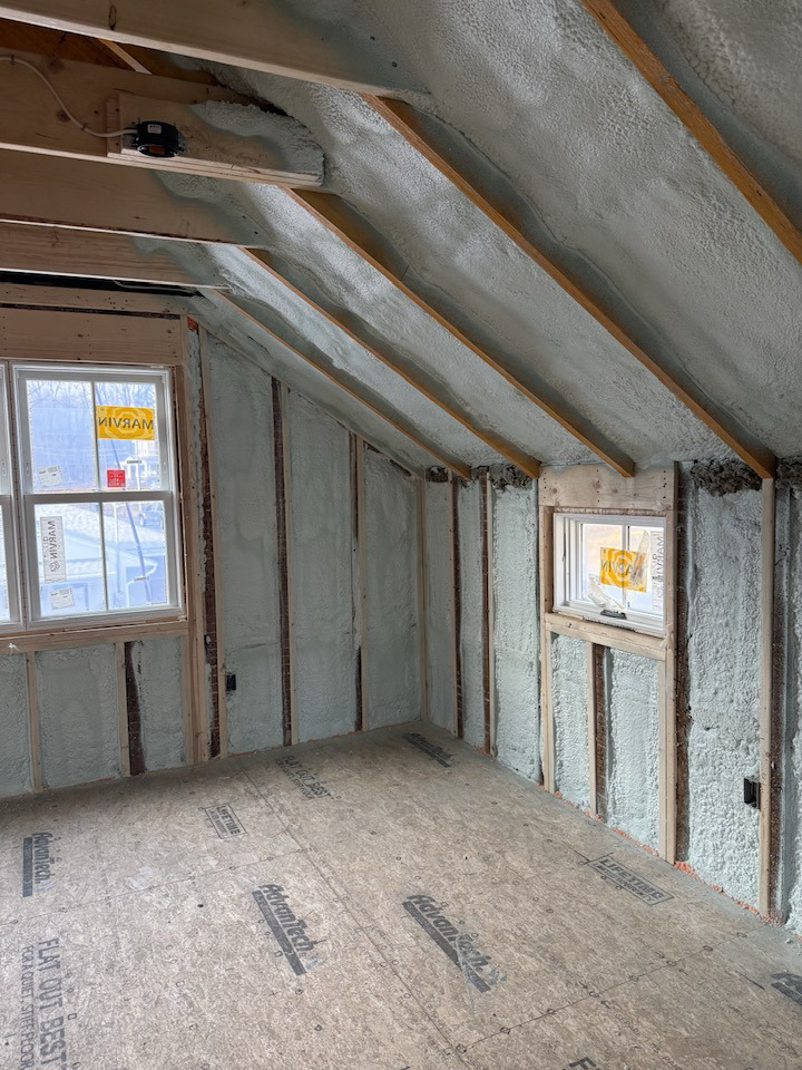 Room under renovation with spray foam insulation on sloped ceiling and walls by Safco Foam Insulation in Hampden, MA.