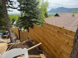 A horizontal wood fence installed on a sloped terrain by GreenView Solutions in Denver, CO.