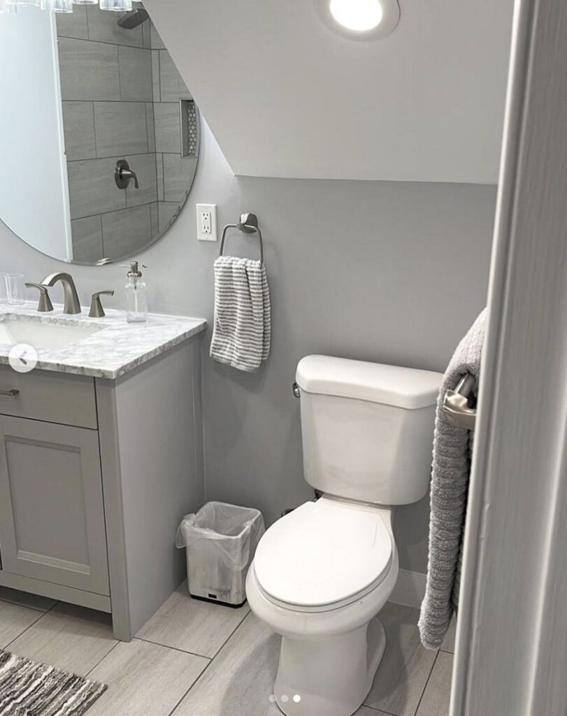 A small, modern bathroom remodel featuring a new vanity, toilet, and tiled shower by Ruach Home Services in Laurel, MD.