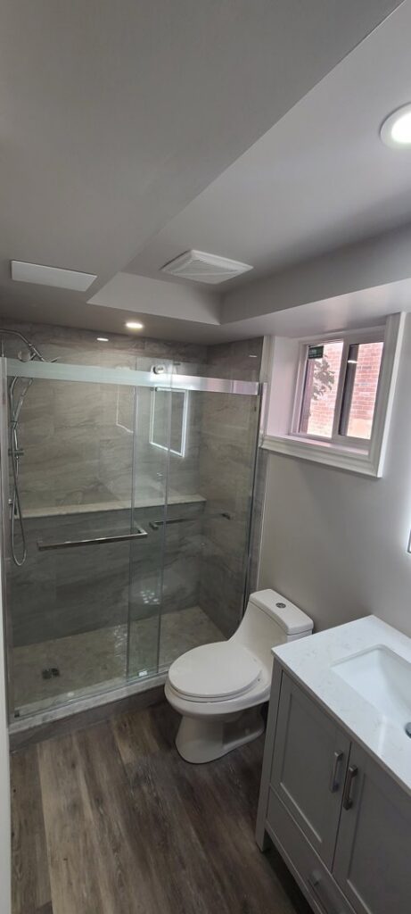 A small bathroom remodel featuring a walk-in shower, toilet, and vanity by NP General Contracting in Austin, TX.