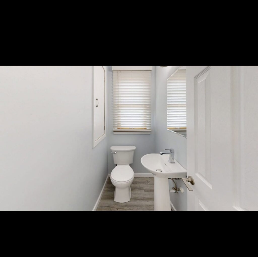 A small bathroom remodel featuring new paint, toilet, and pedestal sink, expertly done by EJ Drywall Plus in Kearney, NE.