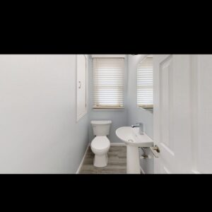 A small bathroom remodel featuring new paint, toilet, and pedestal sink, expertly done by EJ Drywall Plus in Kearney, NE.