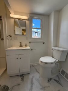 A newly renovated small bathroom with a modern white vanity and toilet by 3Rivers General Contracting in Pittsburgh, PA.
