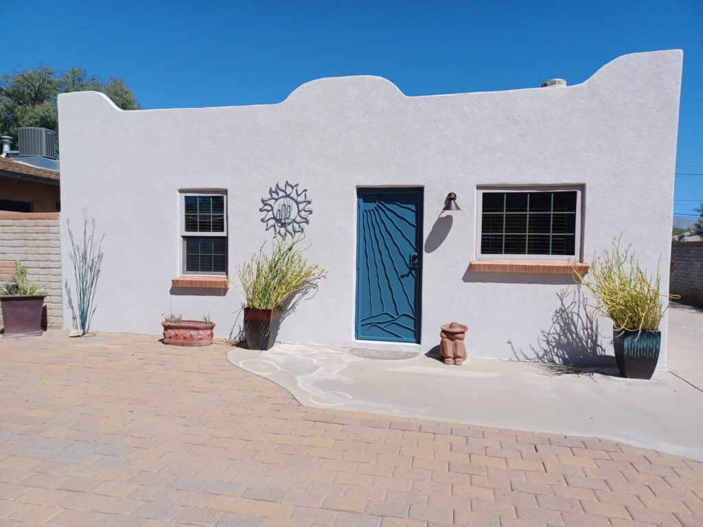 A small building with a fresh stucco finish and a blue door by Old Pueblo Stucco, Inc. in Tucson, AZ