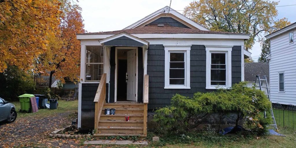 Small house exterior after renovation, featuring dark siding, new windows, and a rebuilt porch by NS Construction in Imperial, CA.