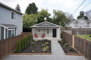 A small house with newly landscaped front yard and wooden fence installed by Gordon T. Jacob in Tacoma, WA