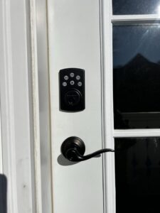 A new smart door lock and handle installed on a white door by Med City Handy Ma'am in Rochester, MN