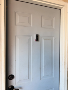 Professional smart doorbell installation on a white door by BZB Fencing & Staining in Fountain Inn, SC.