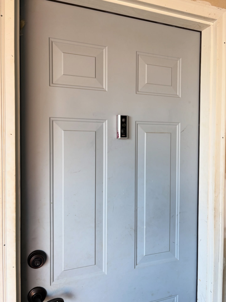 Professional smart doorbell installation on a white door by BZB Fencing & Staining in Fountain Inn, SC.