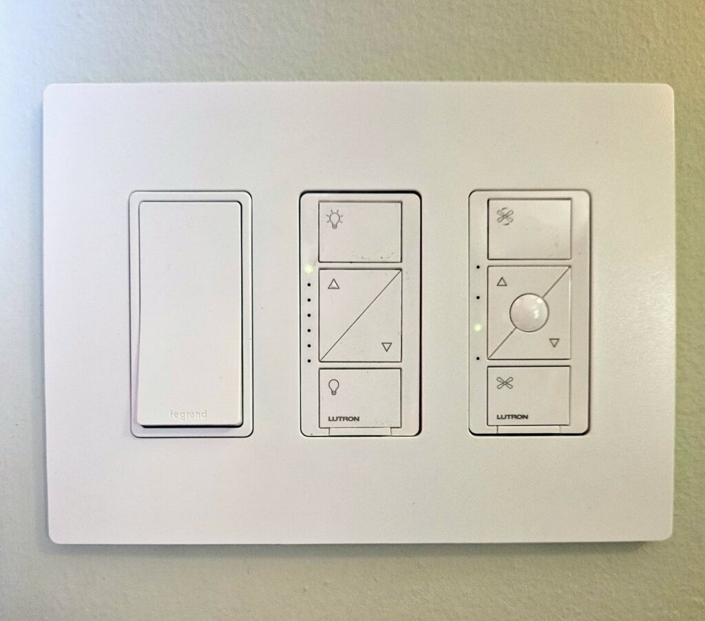 A modern wall plate with smart light and fan control switches professionally installed by MorLite Electric in Newport News, VA.
