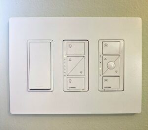 A modern wall plate with smart light and fan control switches professionally installed by MorLite Electric in Newport News, VA.