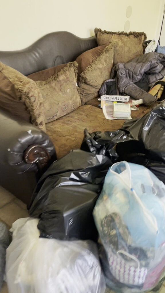 A sofa covered with black trash bags and other items, ready for junk removal by Ron's Rubbish & Junk Removal Cleanout Services in Yonkers, NY.