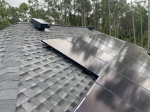 Solar panels and a solar attic fan installed on a residential roof by Koala Insulation of Charlotte, NC