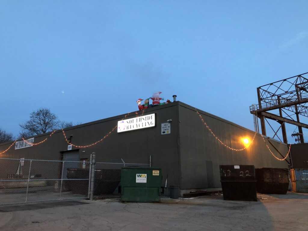 Southside Recycling building exterior at dusk with large junk dumpsters and Christmas lights in Youngstown, OH