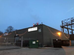 Southside Recycling building exterior at dusk with large junk dumpsters and Christmas lights in Youngstown, OH